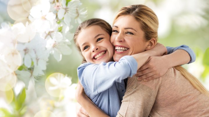 people and family concept - happy smiling mother hugging daughter over cherry blossom background